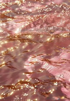 the water is very pink and shiny with some gold flecks on it's surface