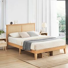 a bed sitting on top of a hard wood floor next to a wooden dresser and lamp