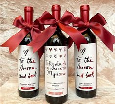 three bottles of wine with red ribbon tied around them