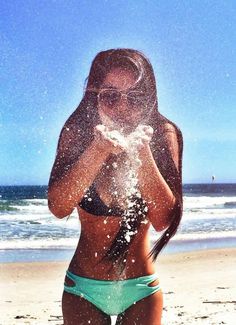 a woman standing on top of a sandy beach