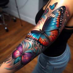 a woman's arm with colorful butterfly tattoos on her left arm and the other arm