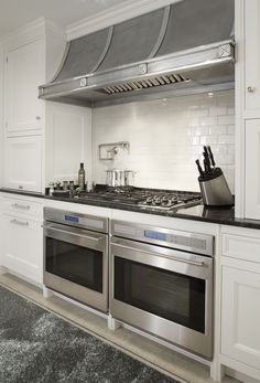 a stove top oven sitting inside of a kitchen next to a counter with knives and utensils on it