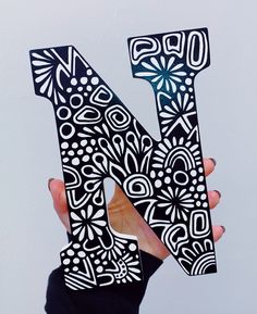 the letter n is made out of black and white paper with intricate designs on it