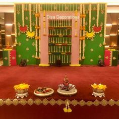 a decorated stage set up for a diwaling ceremony with plates and bowls on the table