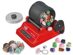 a red candy dispenser with lots of candies in front of it