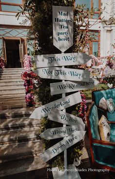 a sign that is on the side of a building in front of some stairs and flowers