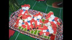 decorated cookies in the shape of santa clause on a tray with scissors and other decorations