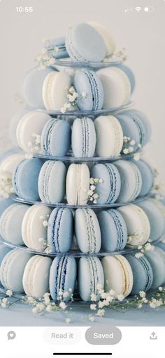 a blue and white cake with macaroons stacked on it's sides in the shape of a pyramid