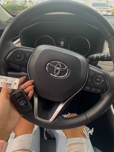 a woman is sitting in the driver's seat of a car holding her keys