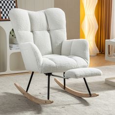 a white rocking chair and ottoman in a living room