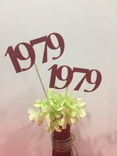 there is a vase with flowers in it and the number 799 spelled on top