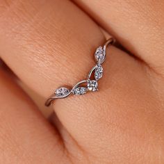 a woman's hand with a diamond ring on top of her finger and the band is