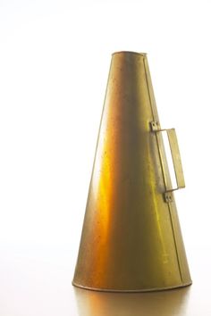 a gold colored vase sitting on top of a white table