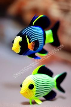 two small plastic fish sitting on top of a table