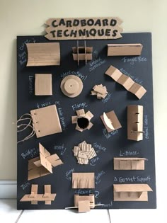 cardboard techniques displayed on a blackboard with chalk writing and magnets attached to it