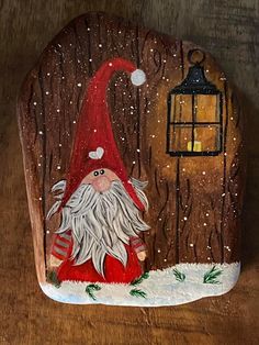 a painted rock with a gnome next to a lantern