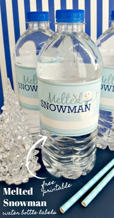 three bottles of water sitting on top of a table next to plastic snowman decorations