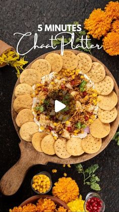 a platter filled with crackers and other food on top of a black table