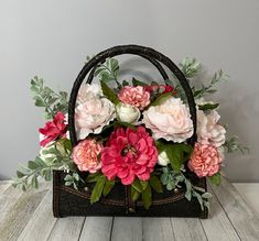 a basket filled with flowers sitting on top of a wooden table