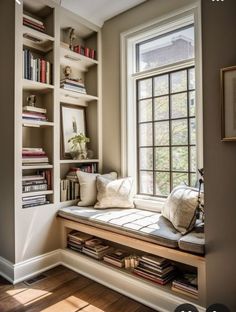 a window seat in front of a bookshelf filled with books