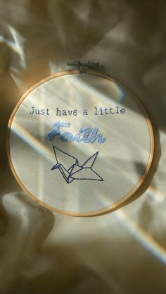 a close up of a embroidery on a piece of cloth with the words just have a little