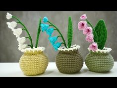 three crocheted vases with flowers in them