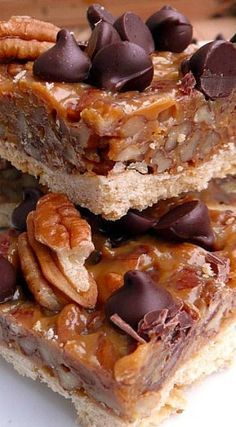 two pieces of pecan bar stacked on top of each other with chocolate chips and nuts