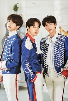 three young men in blue jackets and white pants standing next to each other with their hands on their hips