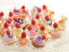 small crocheted cupcakes are displayed on a glass platter with tiny charms