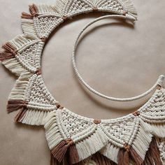 a white and brown necklace with tassels on it