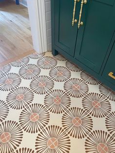 a kitchen floor with an intricate design on the top and bottom, next to a green cabinet