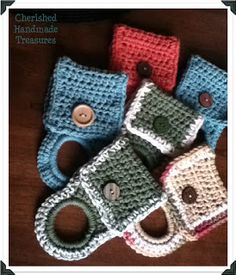 four crocheted baby booties with buttons on the front and bottom, all in different colors