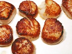 some scallops sitting on top of a white plate