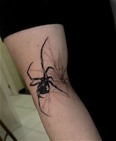 a black and white spider tattoo on the arm