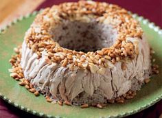 a bundt cake with nuts on it sitting on a green plate