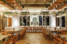 an empty restaurant with tables and chairs set up for formal dinnereons in front of large windows