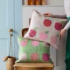 a woman holding two pillows on top of a chair