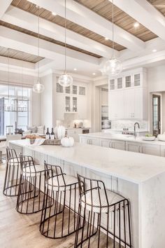 a large kitchen with an island in the middle and lots of stools around it