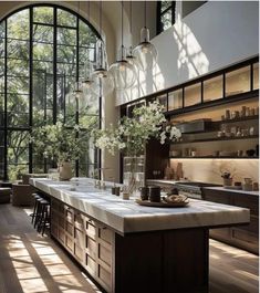 a large kitchen with an island and lots of counter space in front of the windows