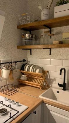 a small kitchen with white tile and wooden counter tops, open shelving above the stove