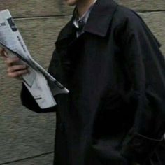 a man walking down the street while holding a newspaper