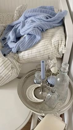 a white table topped with a glass plate covered in blue blankets