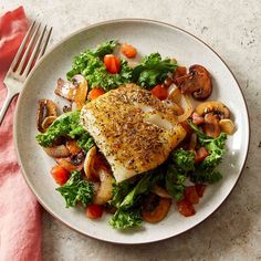 a white plate topped with chicken, vegetables and mushrooms next to a fork on a pink napkin