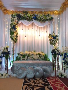 a wedding stage decorated with flowers and greenery