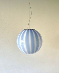 a blue and white striped light hanging from a ceiling