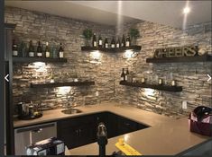 a kitchen with stone walls and shelves filled with bottles