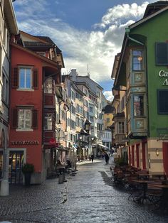 a cobblestone street lined with colorful buildings