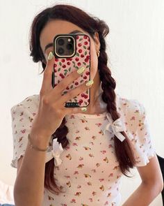 a woman taking a selfie with her cell phone in front of her face and wearing a flowered dress