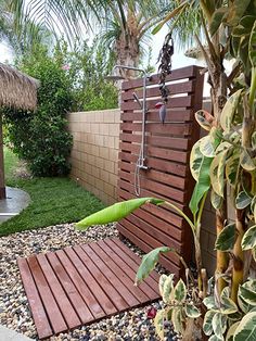 a wooden bench sitting in the middle of a garden next to a lush green tree