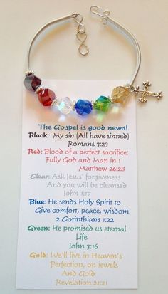 a bracelet with beads and charms on it sitting on top of a white sheet of paper